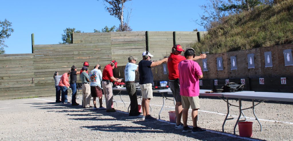 a group of people practicing gun safety on firing range targets with Orange Beach RSOs